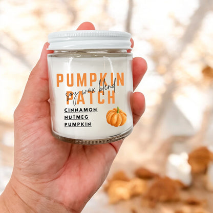A hand holding a 4 oz jar candle labeled 'Pumpkin Patch' with a graphic of a pumpkin and autumn leaves in the background.