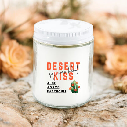 A white candle with the label 'Desert Kiss' featuring an illustration of a cactus, surrounded by desert flowers.